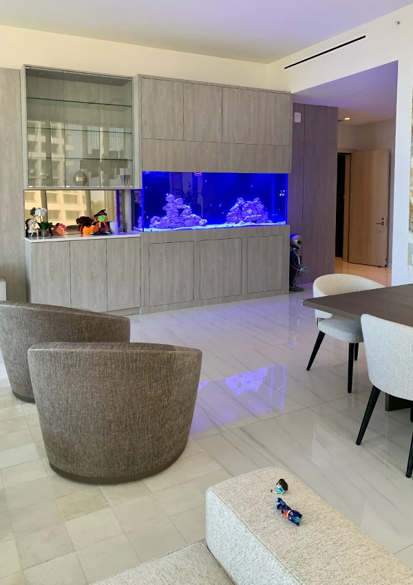 Aquarium integrated into a living-dining room with luxury vitrine side